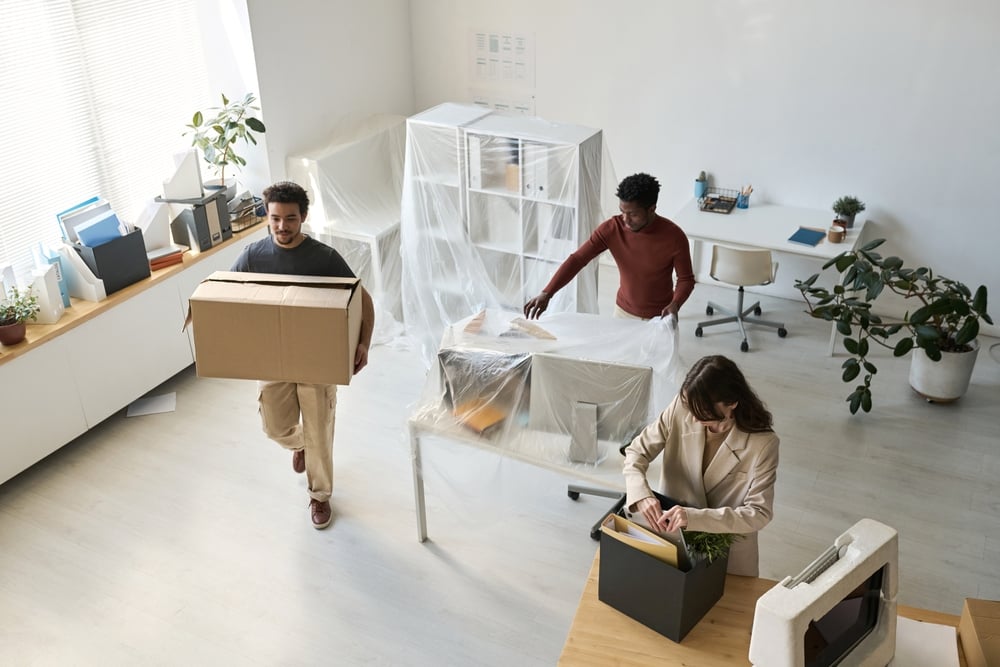 Office relocation checklist - image of people packing up an office.